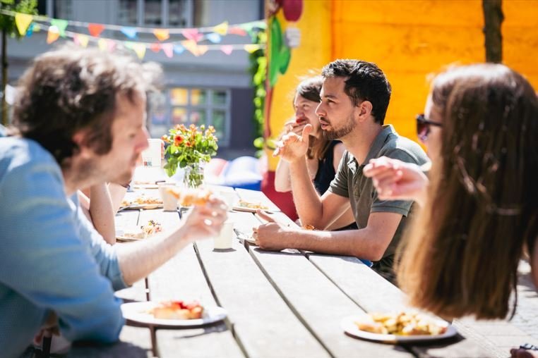 People talking and eating outside.